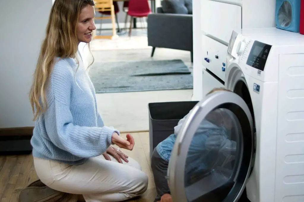 Woman and child sitting in front of washing machine