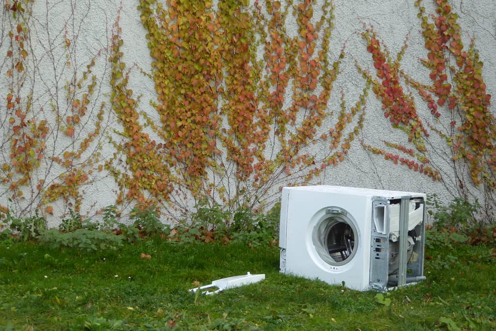 washing machine sitting in the grass outside 